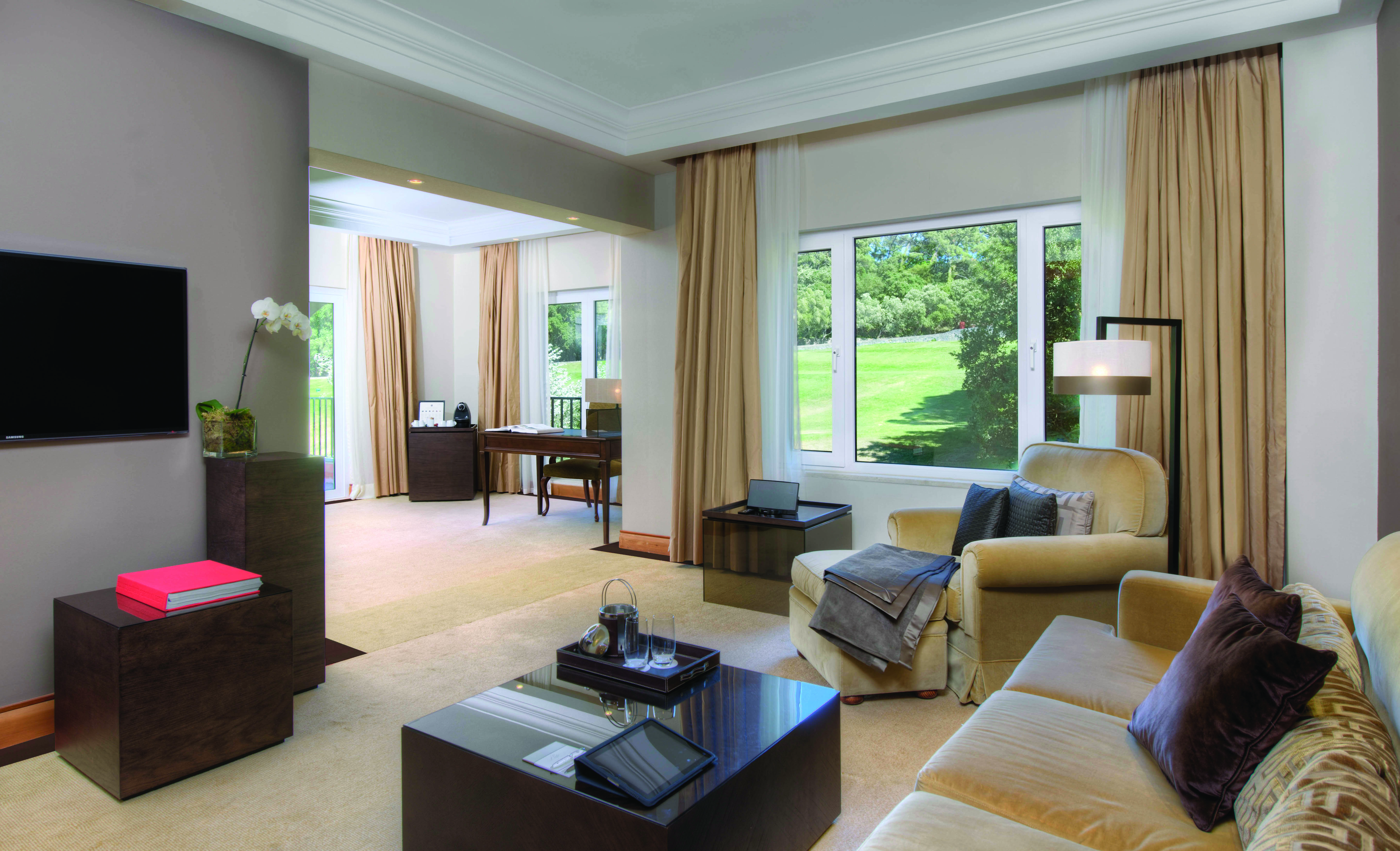 Penha Longa Portugal suite lounge with sofas and chairs and large patio doors