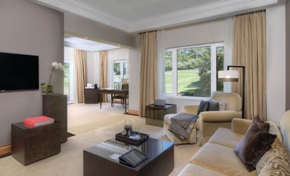 Penha Longa Portugal suite lounge with sofas and chairs and large patio doors
