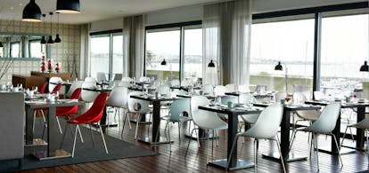 Pestana Cidadela Cascais pool restaurant, tables and chairs, large glass windows with views