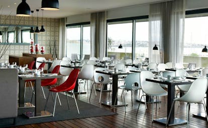 Pestana Cidadela Cascais pool restaurant, tables and chairs, large glass windows with views