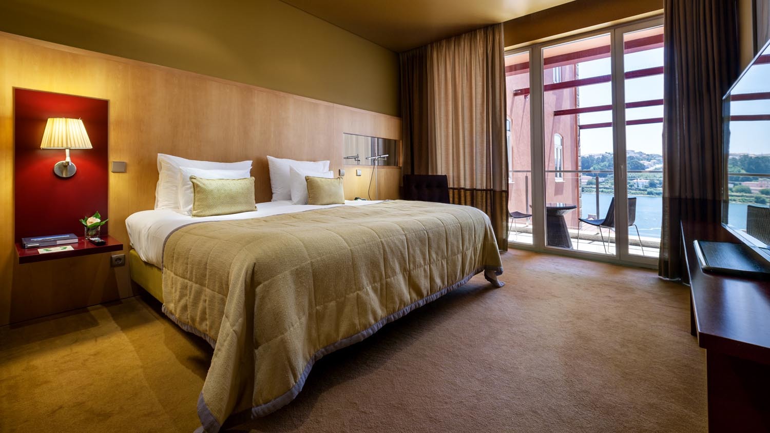 Pestana Palacio do Freixo balcony suite with double bed. leather armchair, french windows leading to blacony