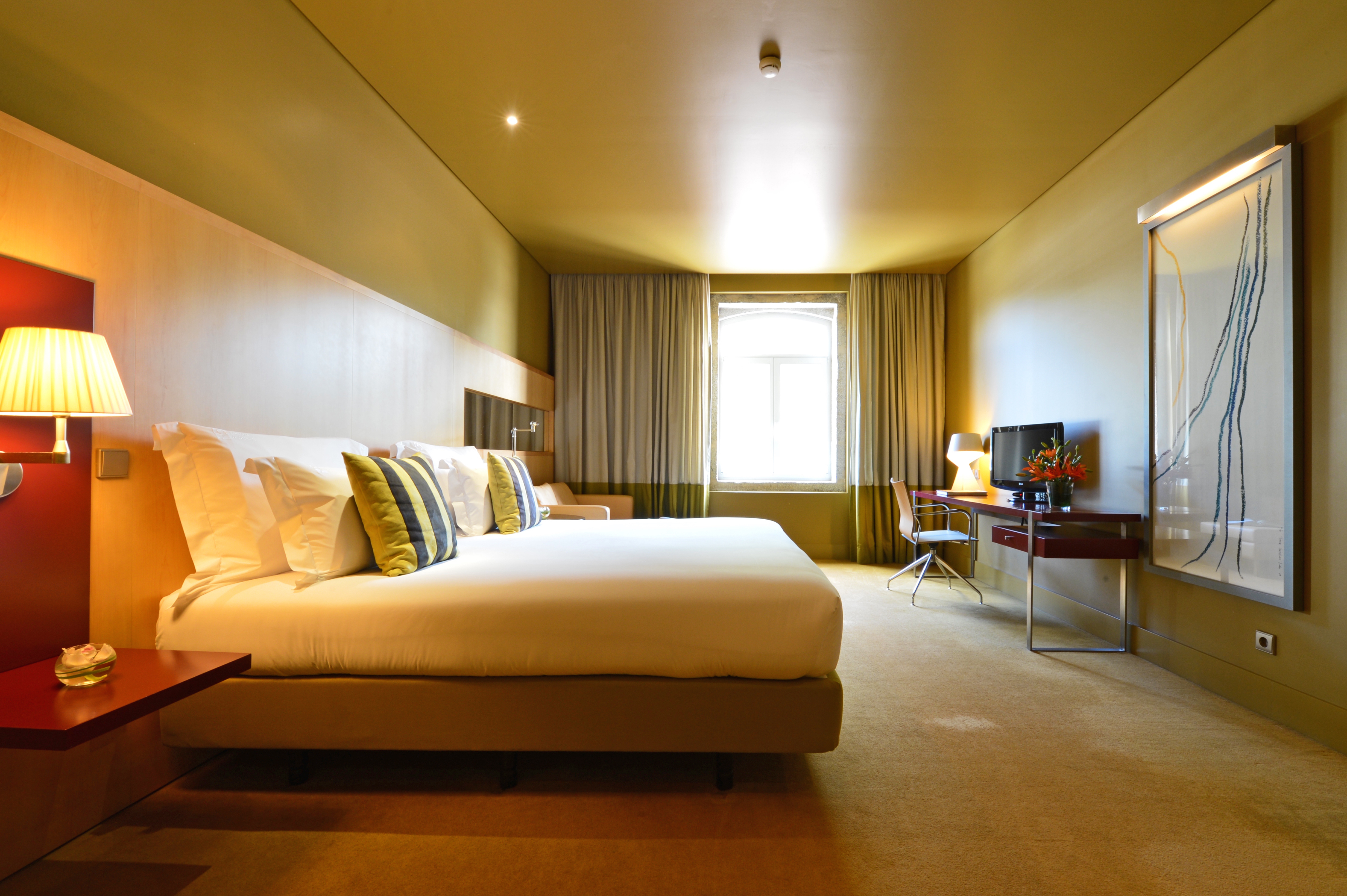 Pestana Palacio do Freixo classic room with double bed desk and chair, decorated in sandy tones, window