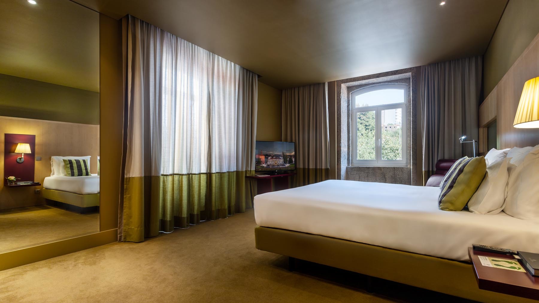Pestana Palacio do Freixo executive room with double bed and sofa, decorated in light greens and beige