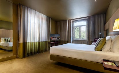 Pestana Palacio do Freixo executive room with double bed and sofa, decorated in light greens and beige