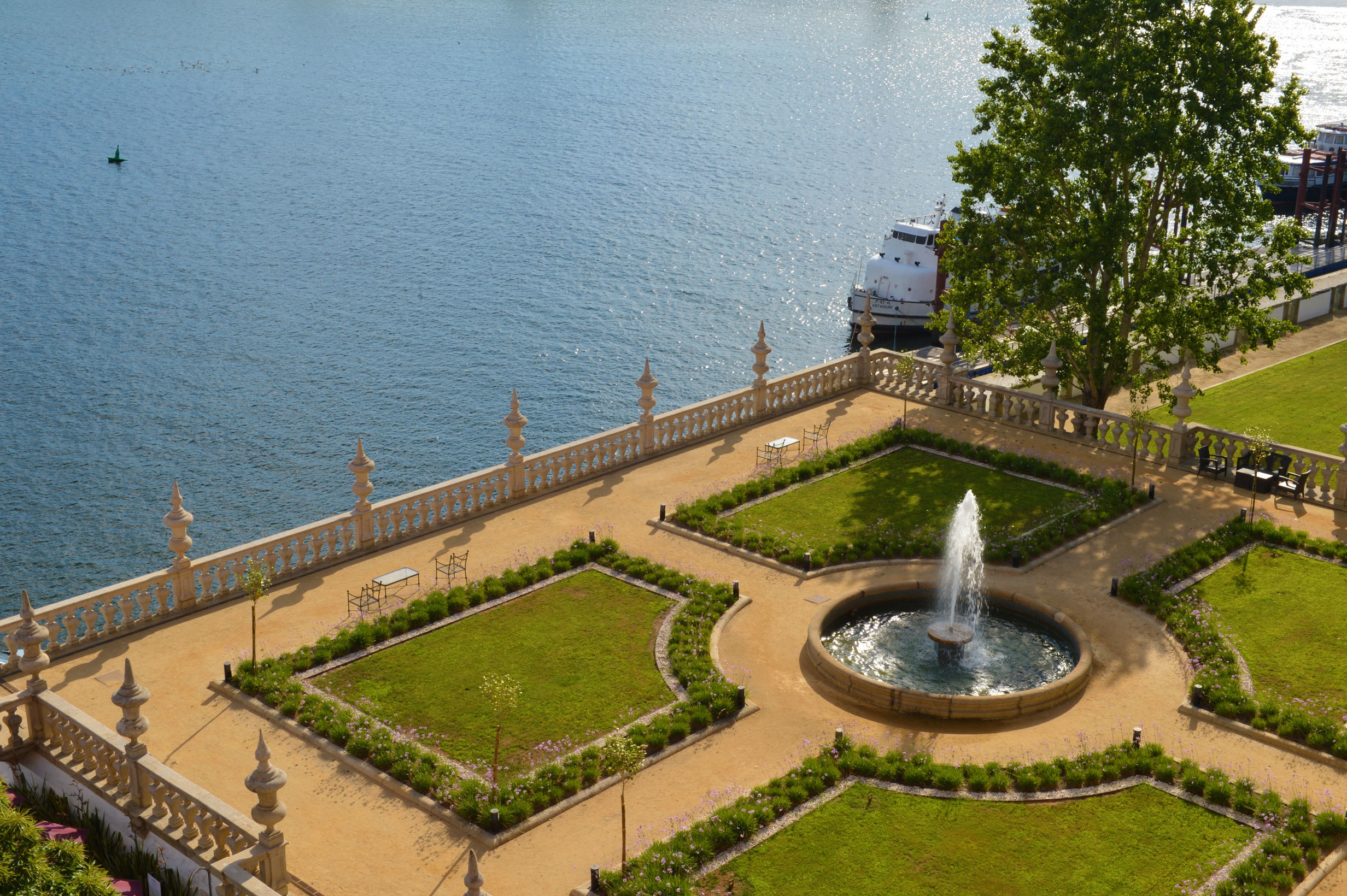Pestana Palacio do Freixo gardens, manicured lawn in square formation, fountain in centre, wall to river