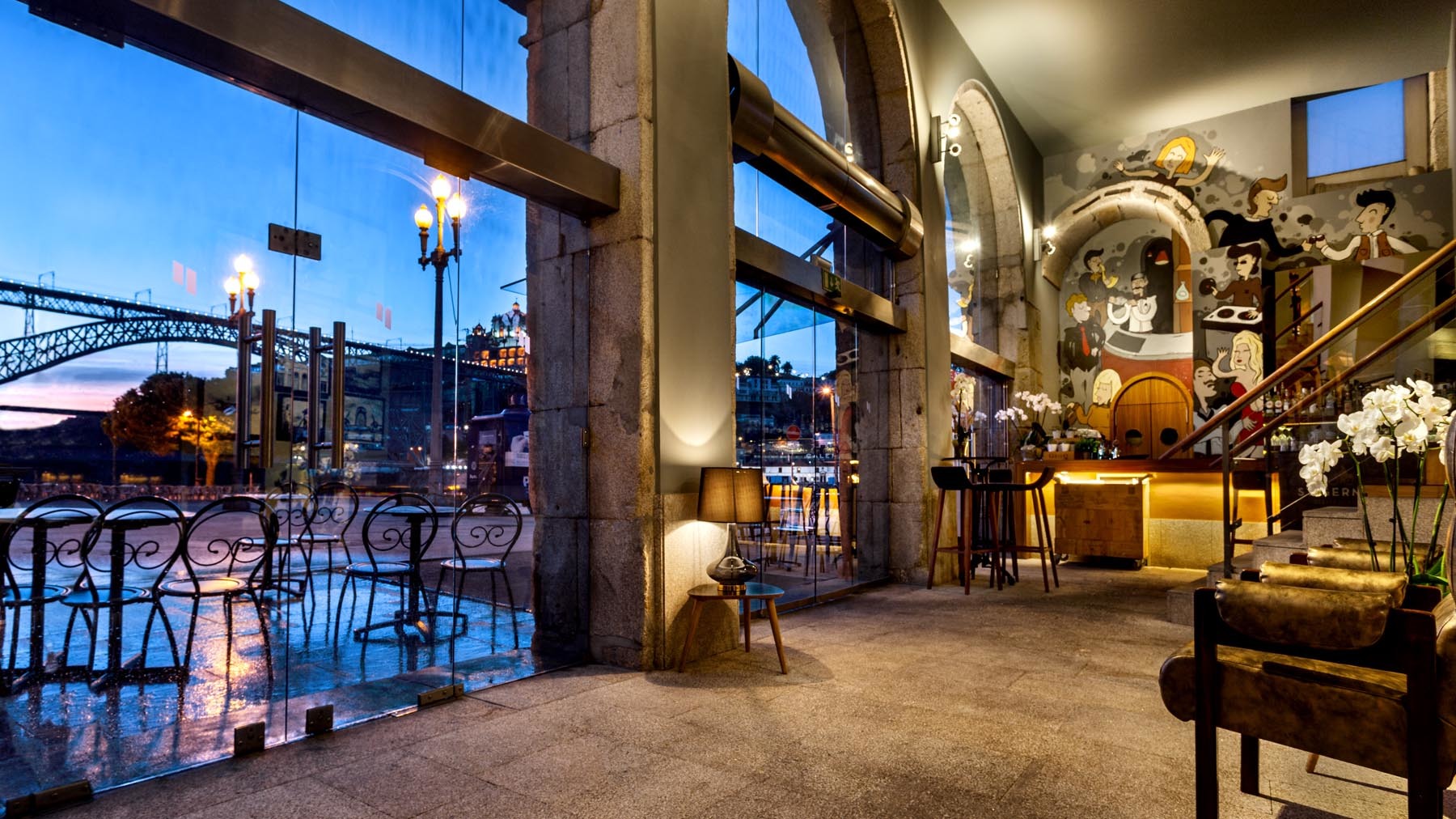 Pestana Vintage Porto bar, stone floors, wooden chairs, colourful wall mural