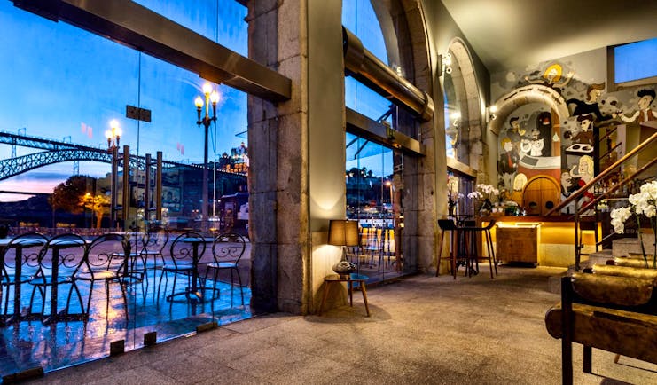 Pestana Vintage Porto bar, stone floors, wooden chairs, colourful wall mural