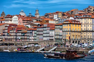 Pestana Vintage Porto exterior, yellow historic building, river bank, boats on the river