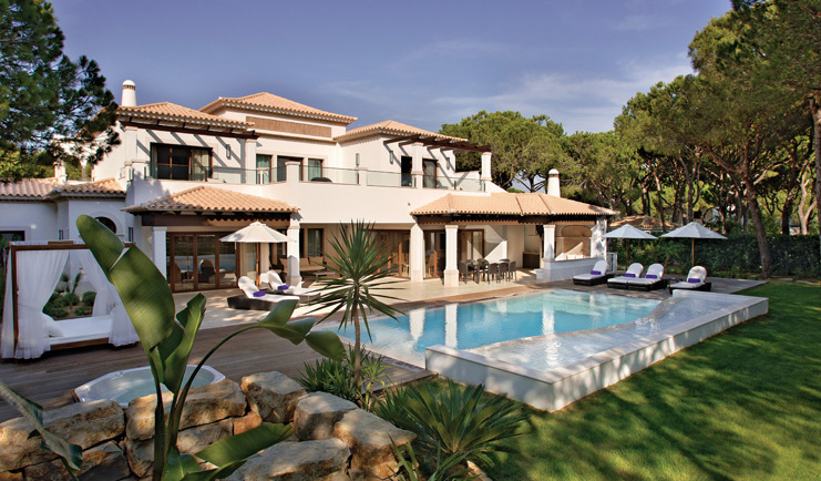 Pine Cliffs Portugal exterior white villa with outdoor pool and sun loungers on deck 