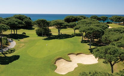 Pine Cliffs Portugal golf course with trees and sea view