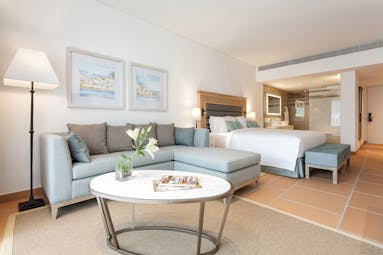 Pine Cliffs Portugal Ocean Suite open plan suite with bed and sitting area with sofa