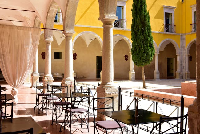 Pousada Convento de Tavira cloisters, outdoor seating, colonnaded cloisters surrounding courtyard with tree