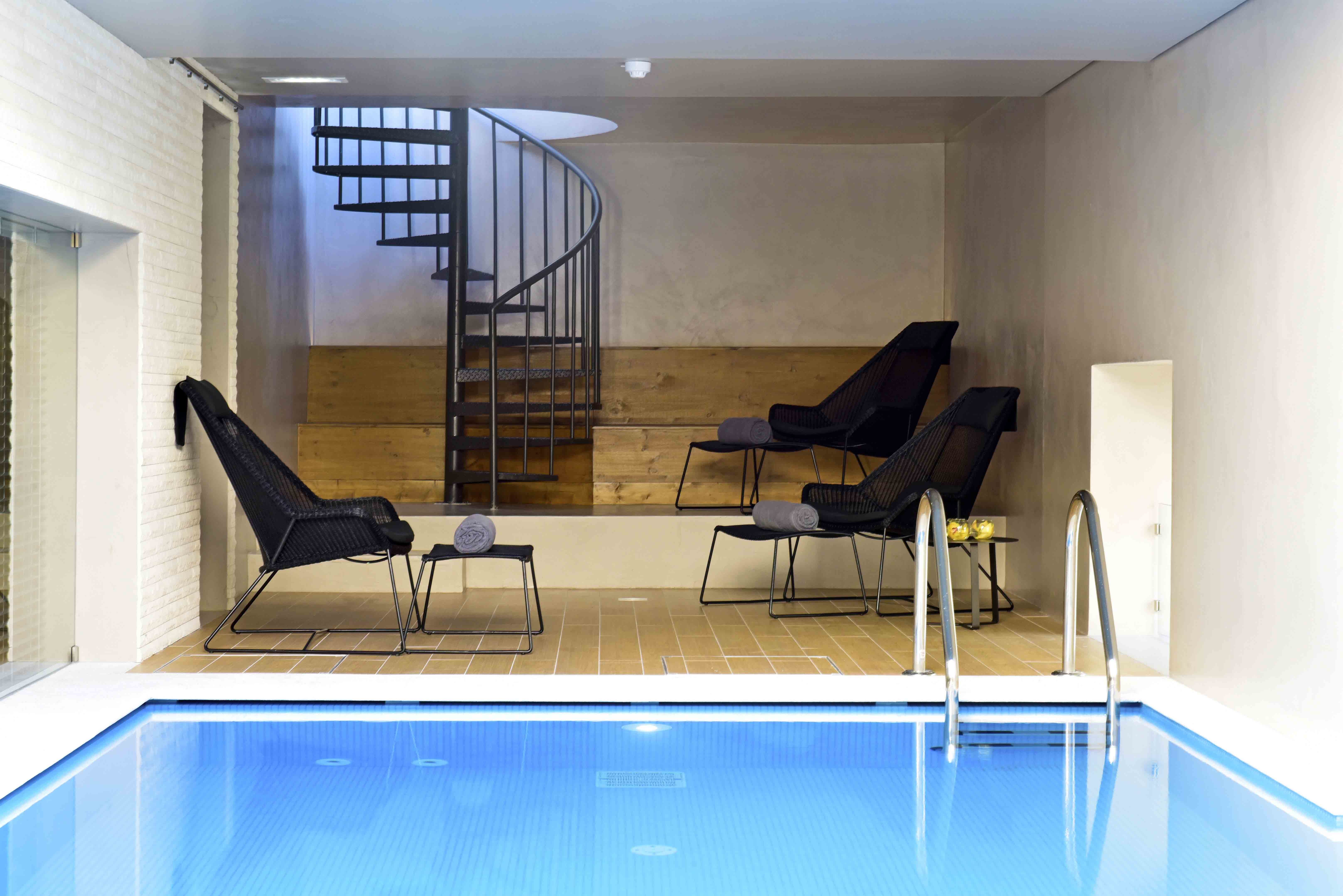 Pousada de Lisboa indoor pool, pool chairs, stairs to upper level
