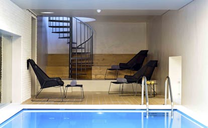 Pousada de Lisboa indoor pool, pool chairs, stairs to upper level