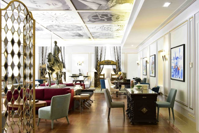 Pousada de Lisboa lobby, modern chairs and tables, images on ceiling, historic hore sculpture in middle of room