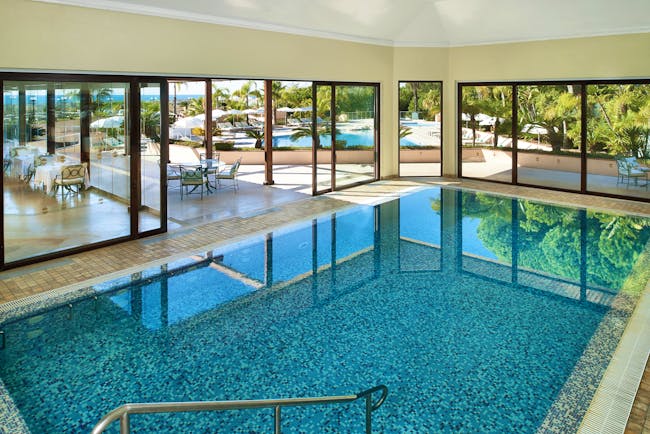 Quinta do Lago Portugal indoor pool with large windows and view of outdoor pool
