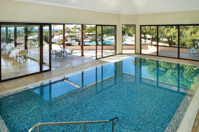 Quinta do Lago Portugal indoor pool with large windows and view of outdoor pool
