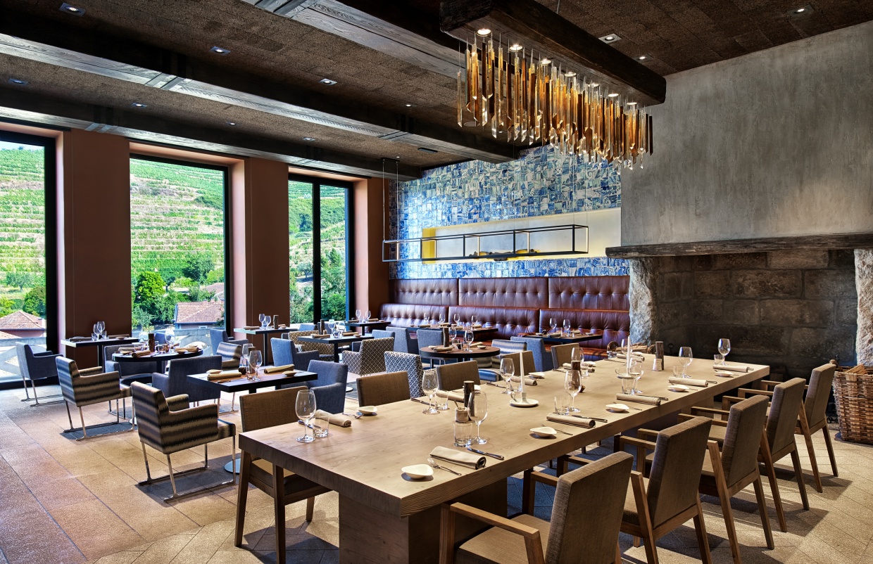 Six Senses Douro Valley Portugal dining room with large fireplace and floor to ceiling windows