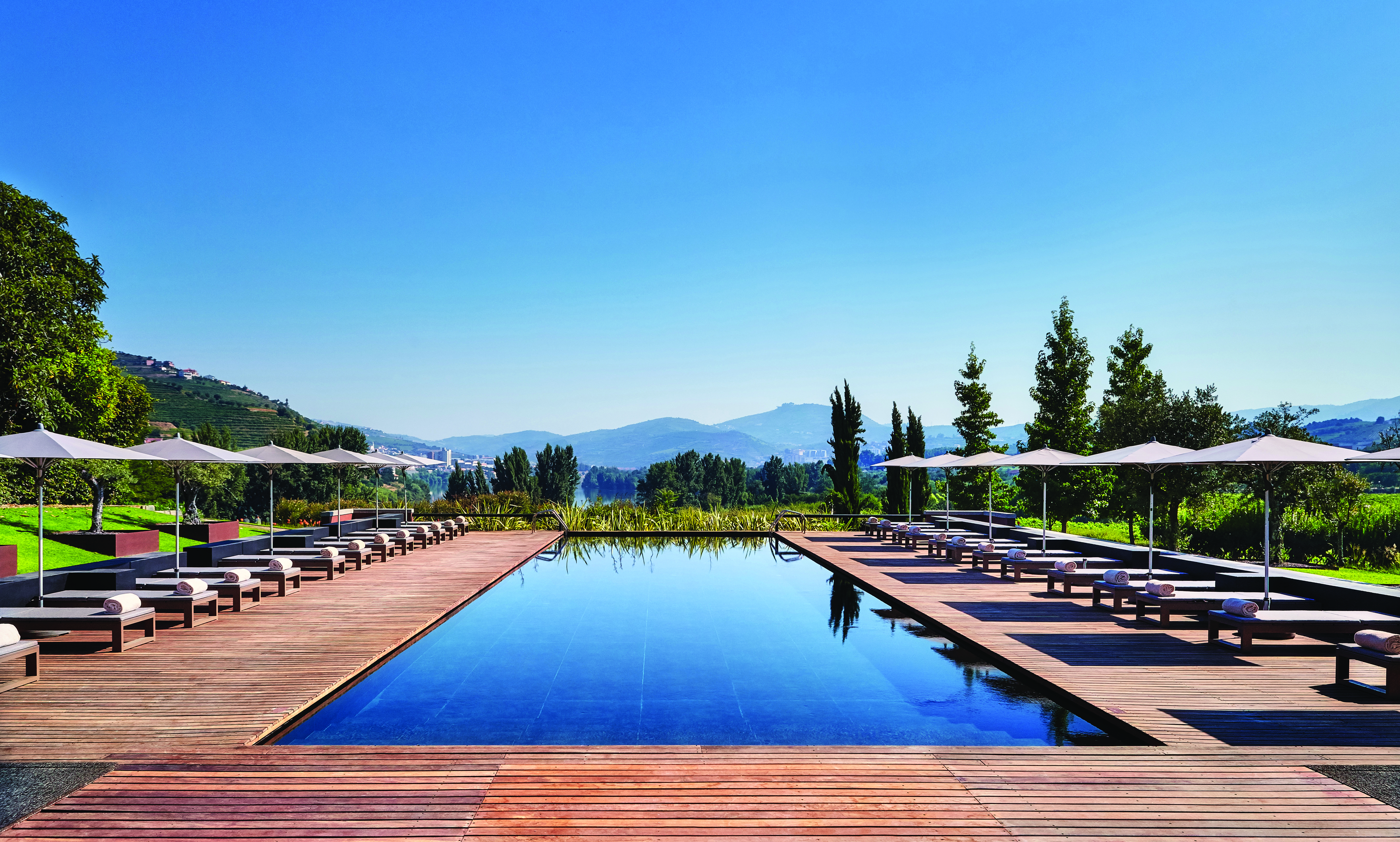 Six Senses Douro Valley Portugal outdoor pool with decked area sun loungers and umbrellas