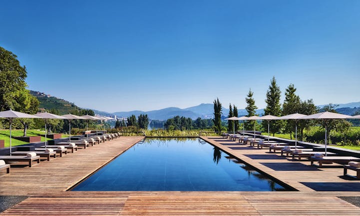 Six Senses Douro Valley Portugal outdoor pool with decked area sun loungers and umbrellas