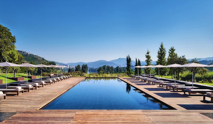 Six Senses Douro Valley Portugal outdoor pool with decked area sun loungers and umbrellas