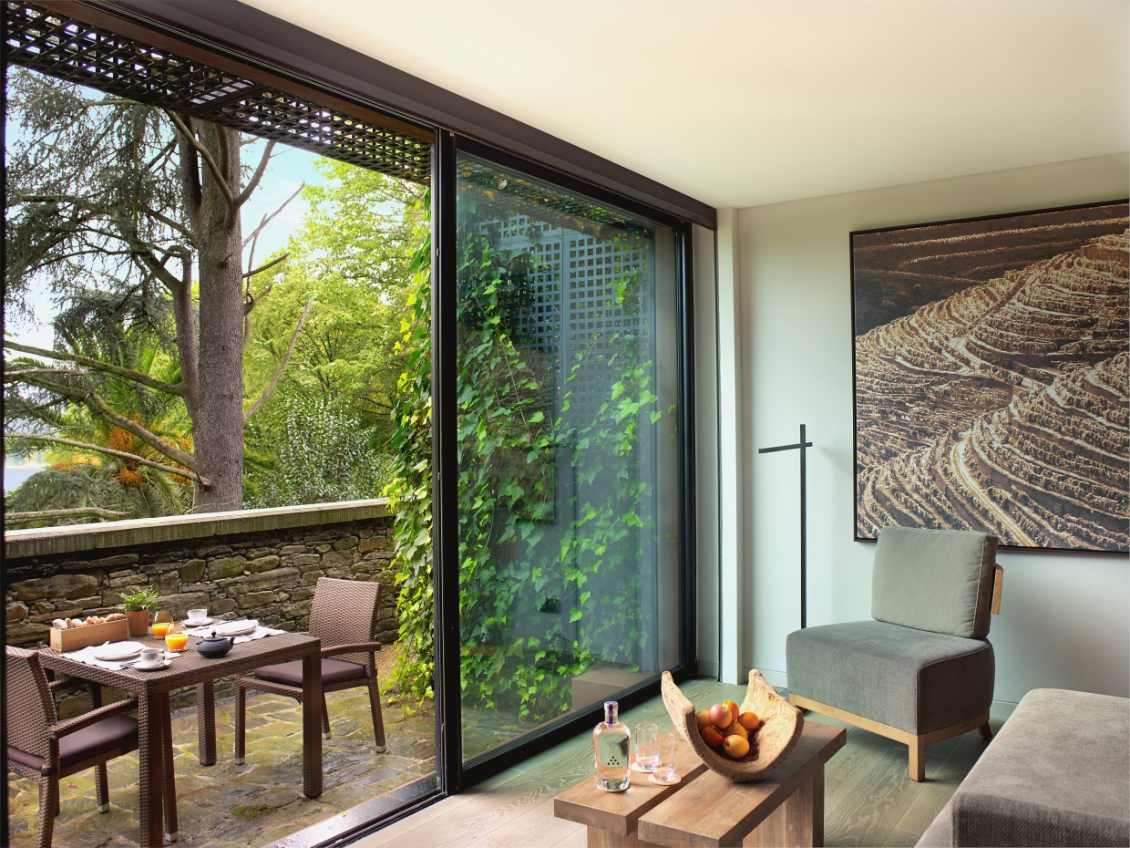 Six Senses Douro Valley Portugal quinta deluxe bedroom with bathroom and seating area and floor to ceiling windows