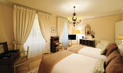 Tivoli Palacio de Seteais Portugal deluxe bedroom with two large beds and large windows with drapes