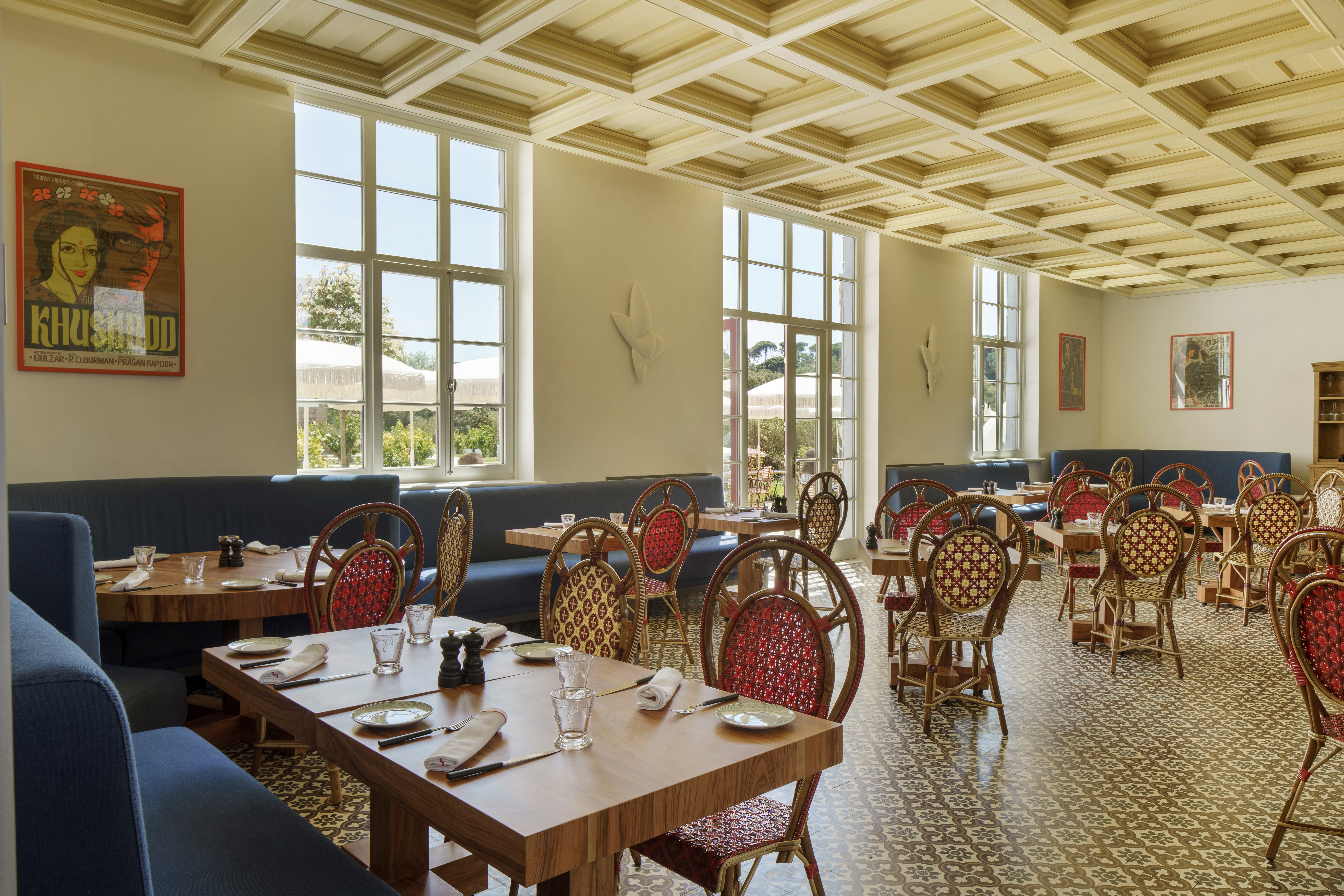 Vermelho Melides Xtian Restaurant with grand high ceilings, large windows, and elegant red and blue chairs
