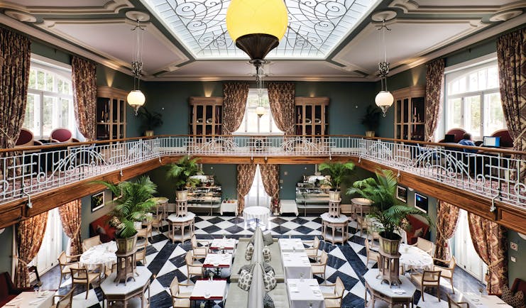 Vidago Palace Portugal winter garden restaurant indoor dining room with balcony glass ceiling and black and white tiles