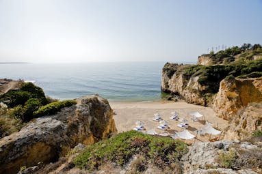 Vila Vita Parc Portugal beach cove with umbrellas and loungers