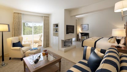 Vila Vita Parc Portugal Oasis family suite bedroom with striped sofa and balcony