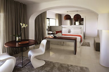 Suite at the vilalara thalassa resort in portugal with a grey and white colour scheme, large double bed and chairs