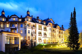 Grandhotel Stary Smokovec exterior, grand hotel building at night, lit up front lawn, trees