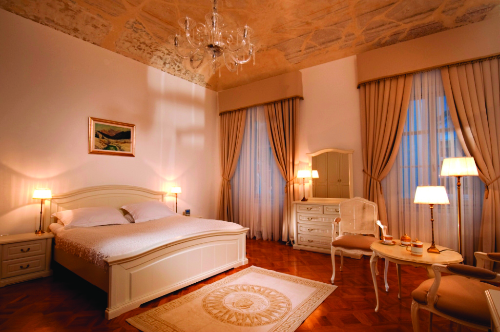 Antiq Palace Hotel Ljubljana bedroom dresser and mirror large windows and a chandelier