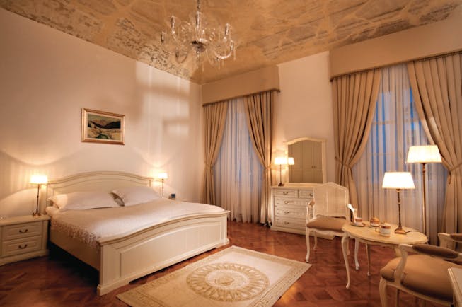 Antiq Palace Hotel Ljubljana bedroom dresser and mirror large windows and a chandelier