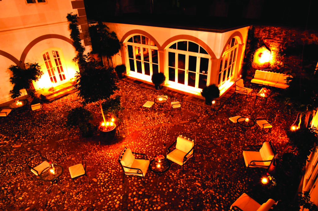 Antiq Palace Hotel Ljubljana courtyard at night time with several chairs and sofas
