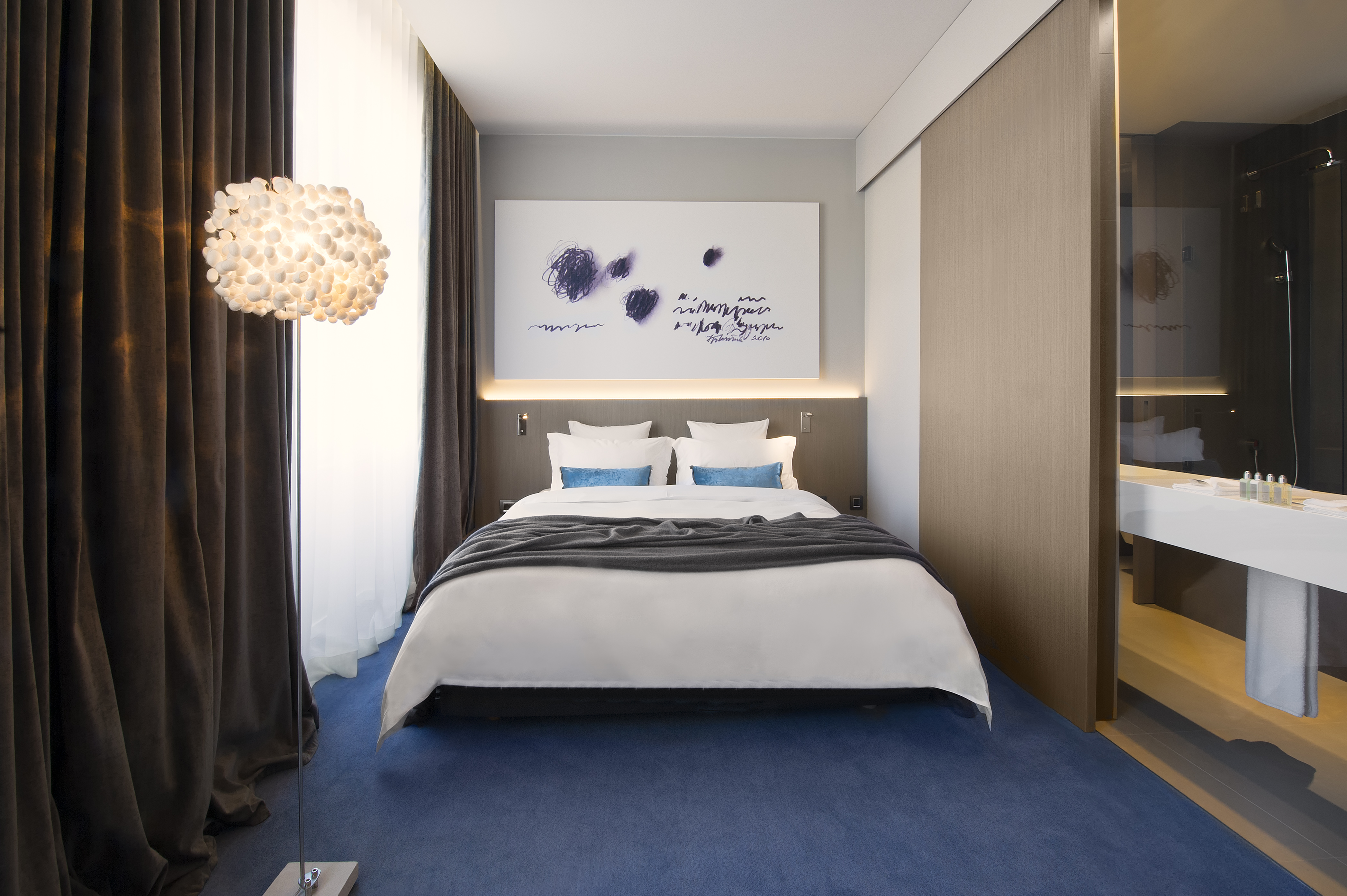 Hotel Cubo double room, bed, painting above bed, bright modern decor