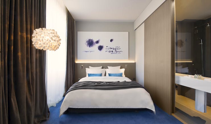 Hotel Cubo double room, bed, painting above bed, bright modern decor