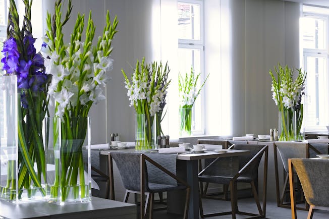 Hotel Cubo restaurant, tables ad chairs, fresh flowers in vases, white bright decor