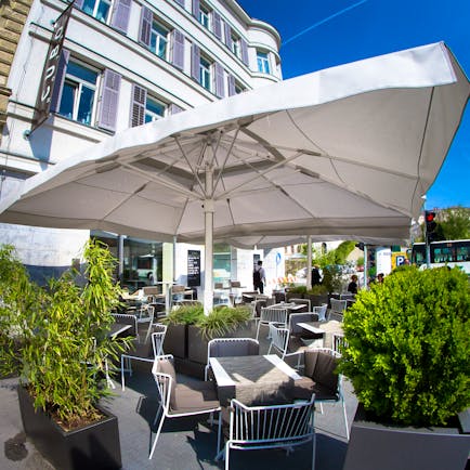 Hotel Cubo terrace, outddor dining area, tables and chairs shaded by umbrellas