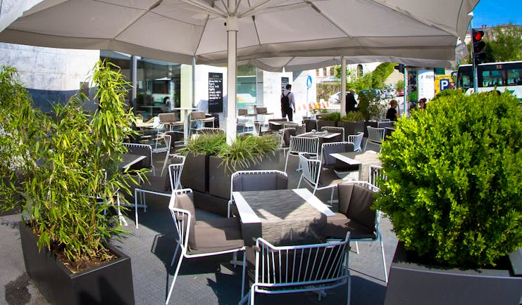 Hotel Cubo terrace, outddor dining area, tables and chairs shaded by umbrellas