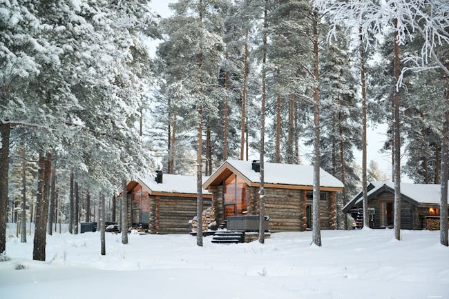 Arctic Retreat cabins exterior, set amongst snowy woodland