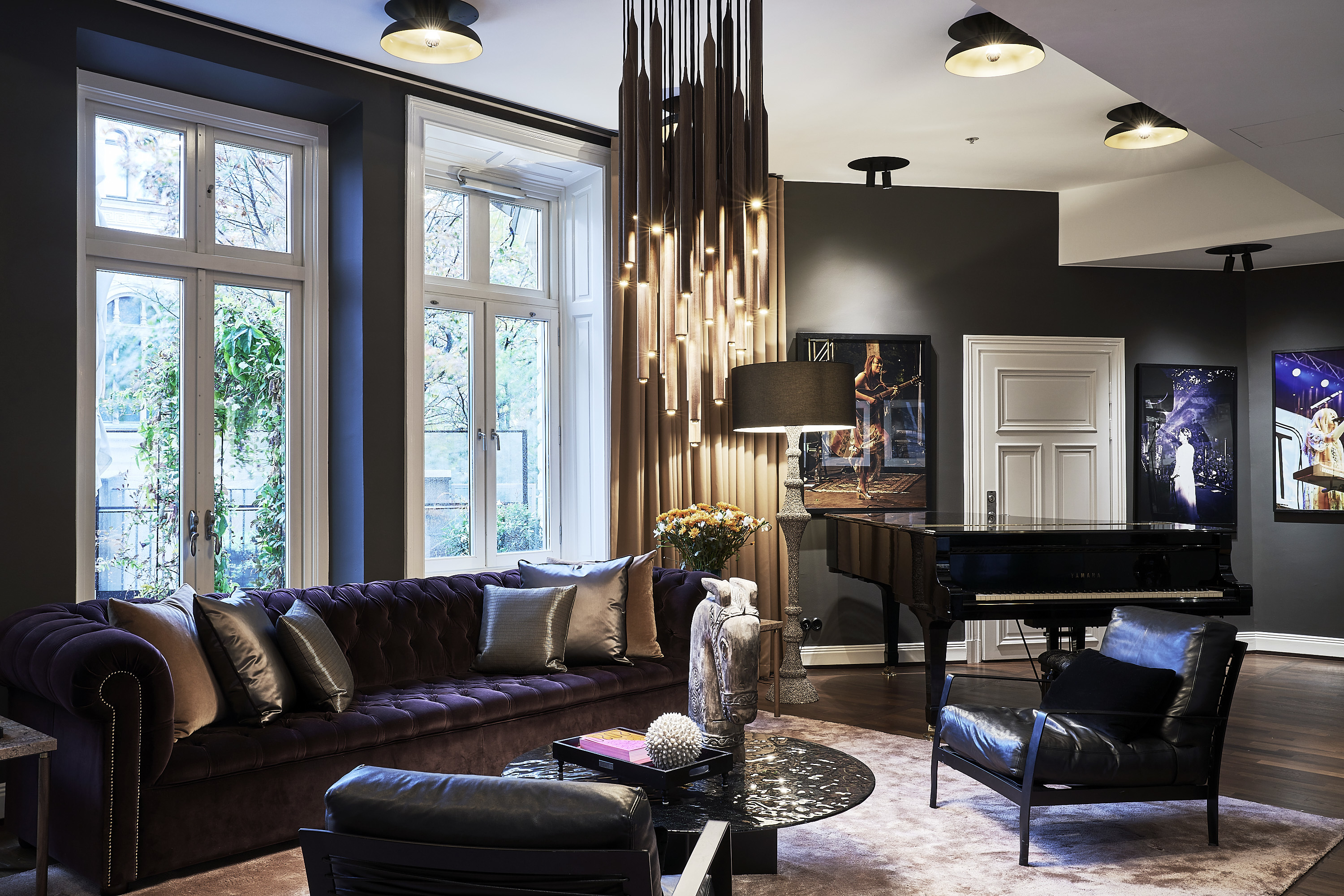 Hotel Lydmar living room, purple velvet sofa, leather armchairs, chandelier, posters on wall