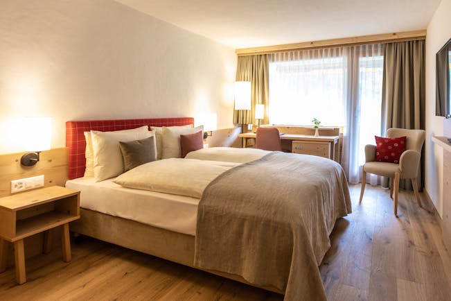 Gstaaderhof bedroom with red head board and wooden floor