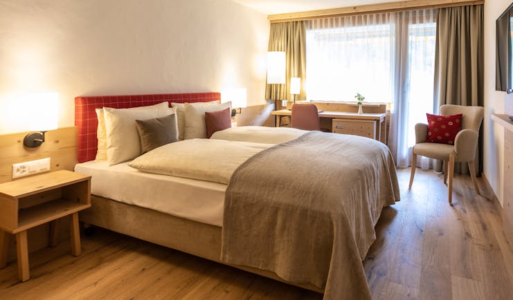 Gstaaderhof bedroom with red head board and wooden floor