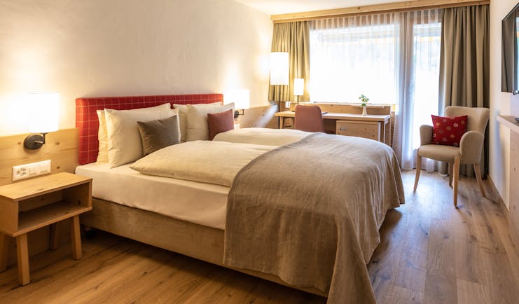 Gstaaderhof bedroom with red head board and wooden floor
