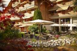 Gstaaderhof wooden chalet hotel with balconies and umbrellas in garden
