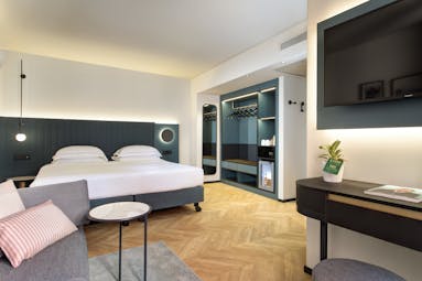 Hotel Lugano Dante premium room, modern stylish decor, bed, wooden floor, sofa, flat screen television on wall