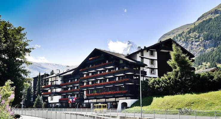 Hotel Alpenhof Zermatt exterior of large chalet hotel with grassy bank newarby