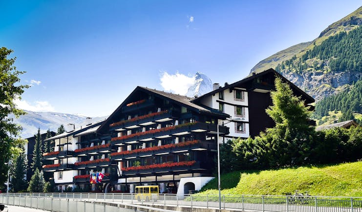 Hotel Alpenhof Zermatt exterior of large chalet hotel with grassy bank newarby